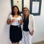 Attorney Denisse with a client holding a card